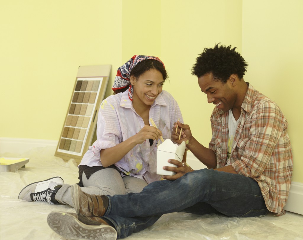 African couple eating take-out in freshly painted room