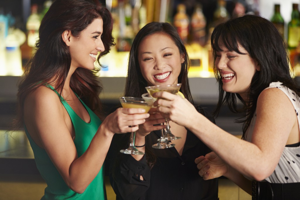 Three Female Friends Enjoying Drink In Cocktail Bar