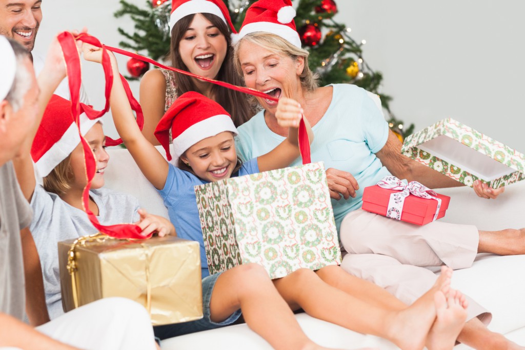 Happy family at christmas opening gifts together