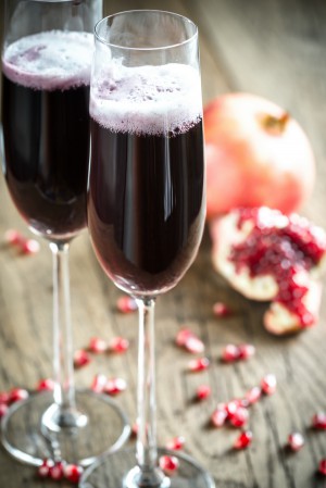Two glasses of champagne with pomegranate seeds