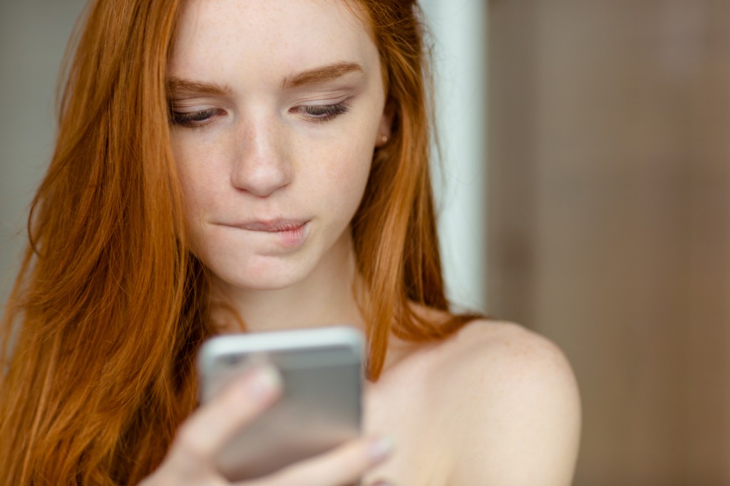 Beautiful redhead woman using smartphone