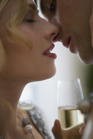 Close-up of young couple with champagne about to kiss