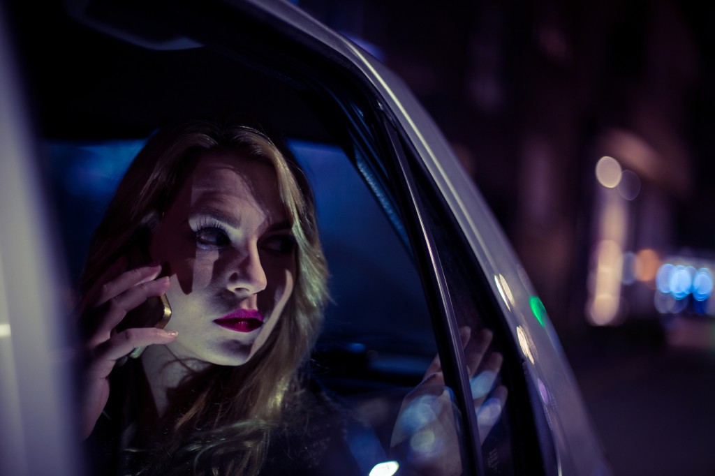 Young woman sitting in a car and using smart phone
